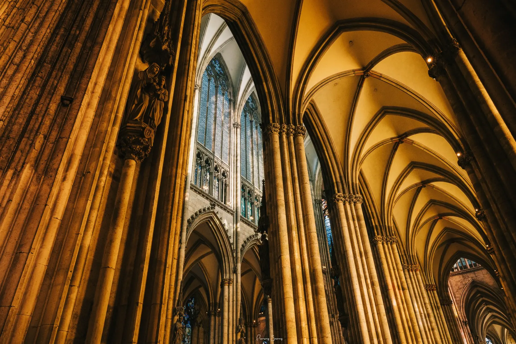Arches gothiques d’une cathédrale révélées par une lumière dorée