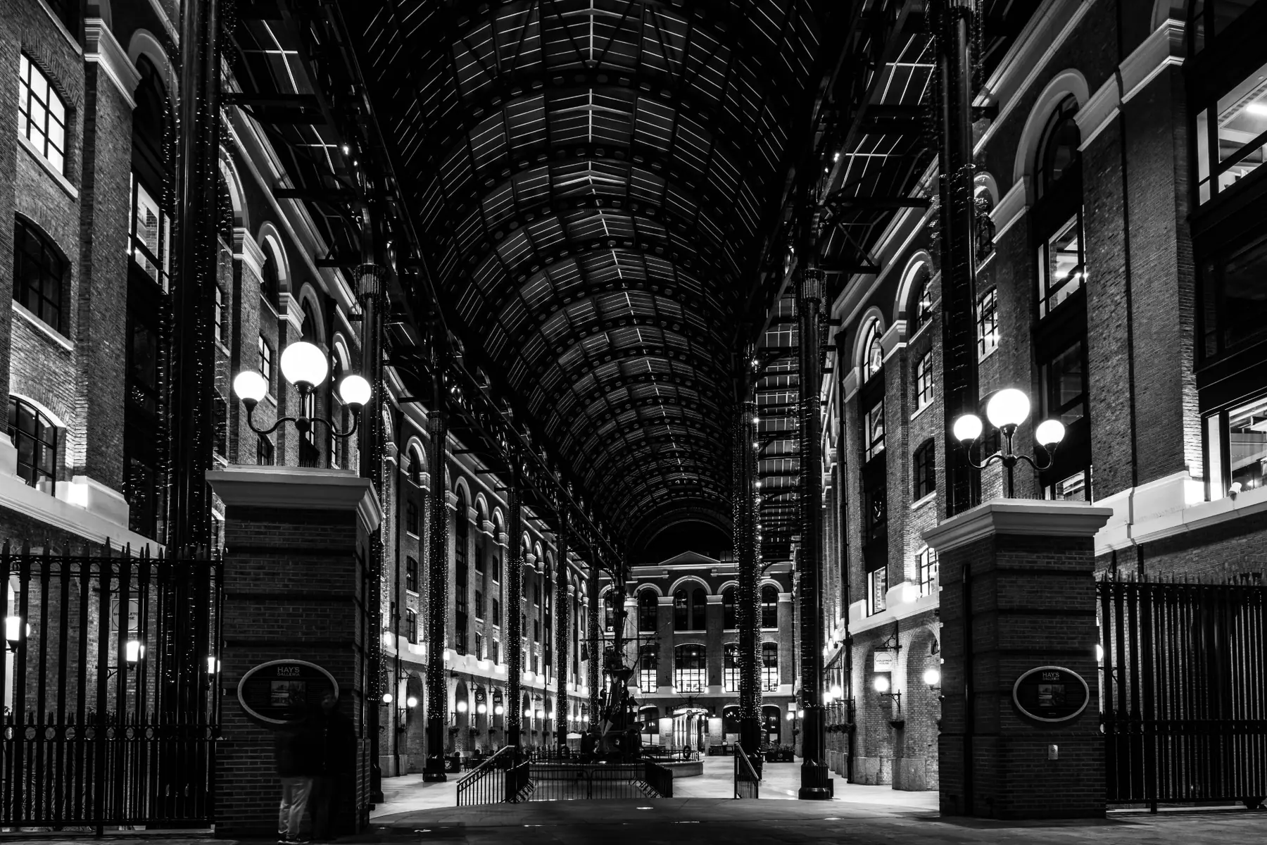 Galerie couverte en noir et blanc construite autour d’une forte symétrie