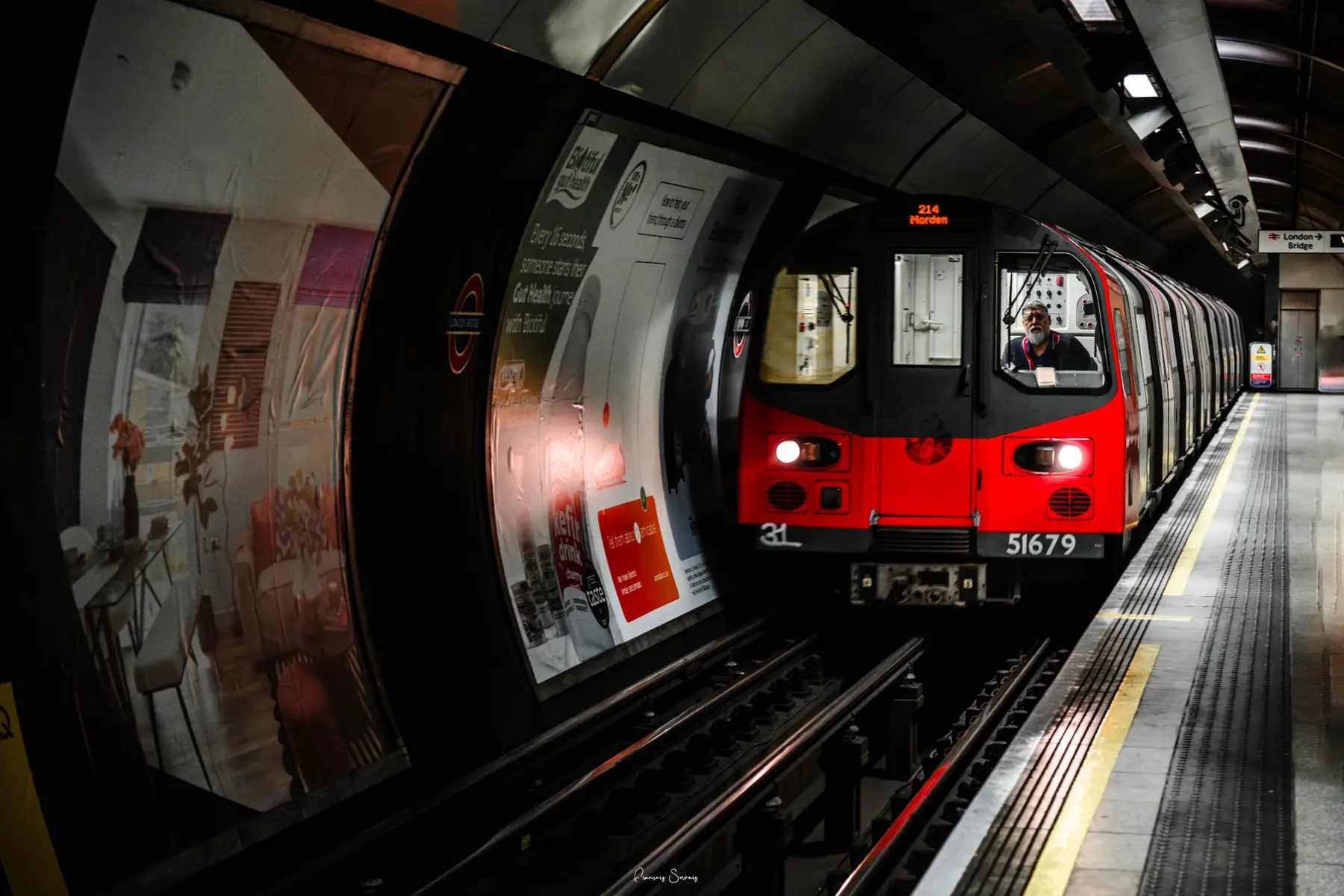 Train rouge sur un quai de métro courbe au rythme très graphique