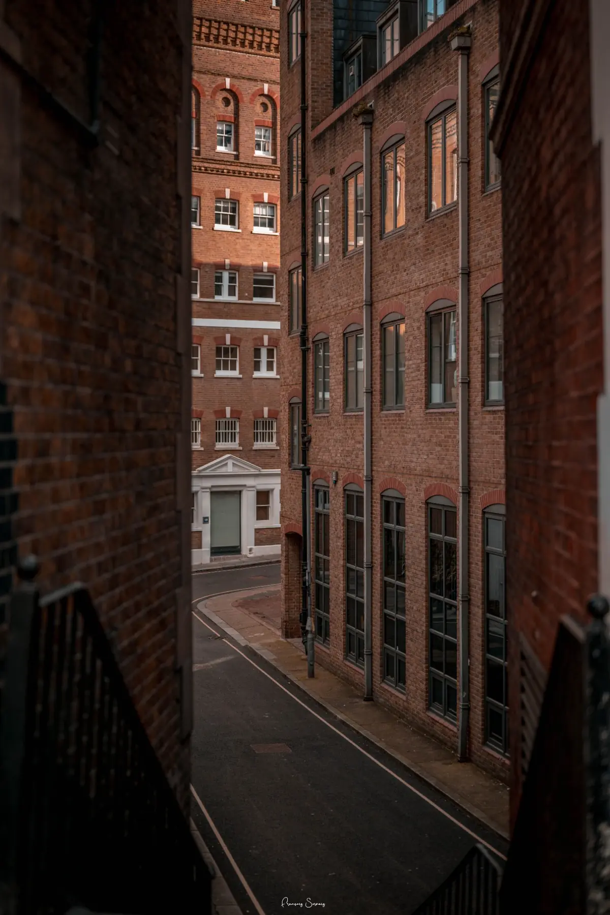 Rue étroite bordée de façades en briques dans une perspective verticale
