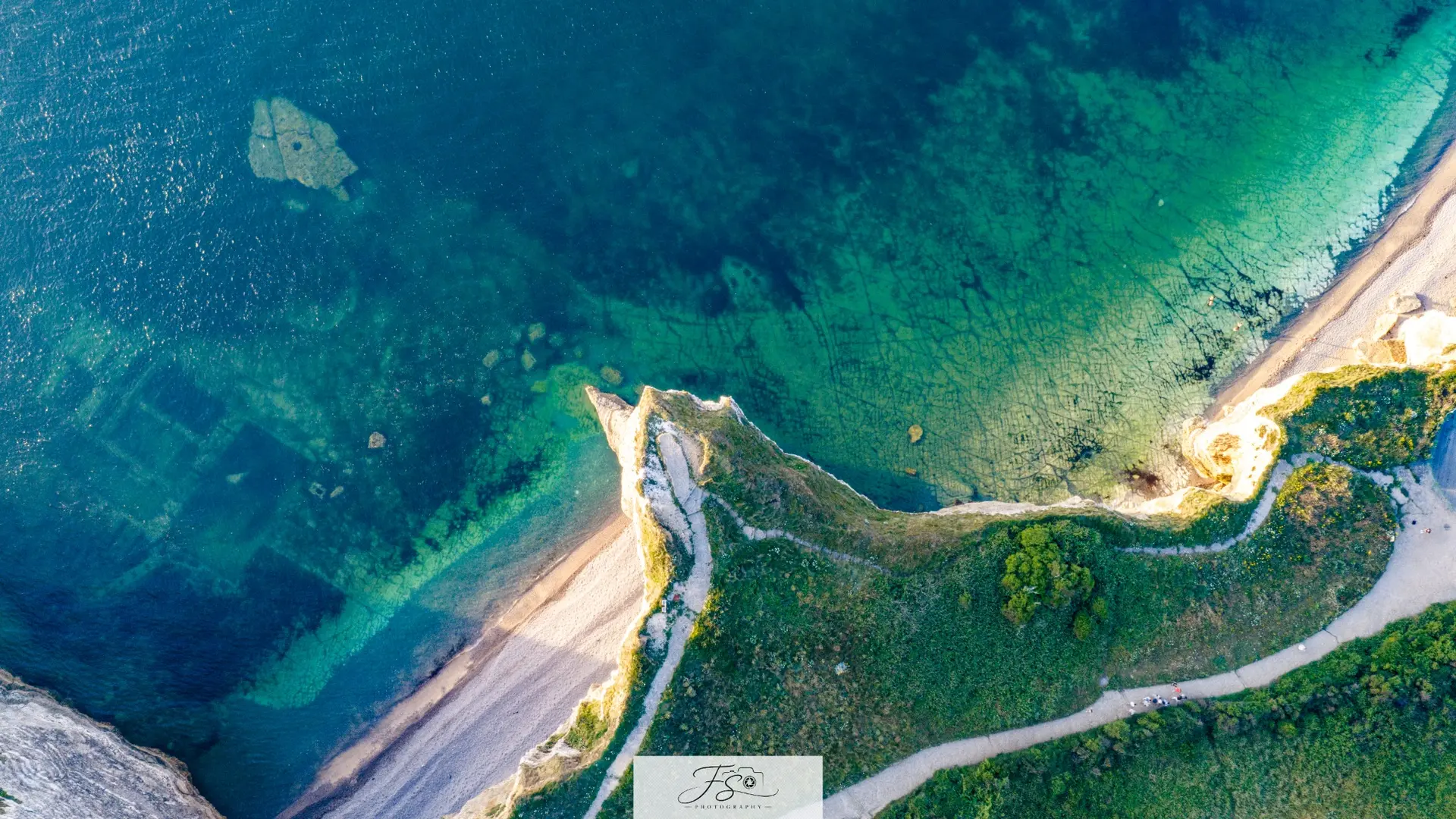 Émeraude — eaux turquoise et sentier côtier vus depuis les airs