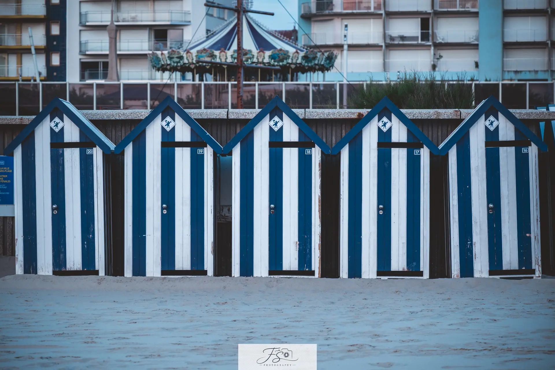 Les cabines bleues — alignement graphique de cabines de plage bleues et blanches