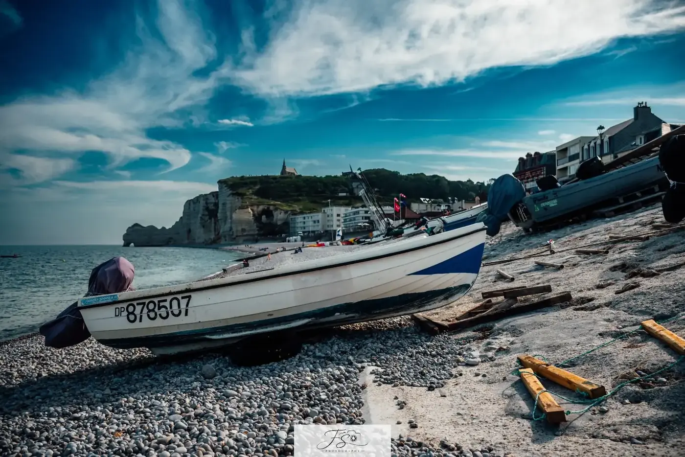 Les barques d’Étretat — barques de pêche sur la plage de galets devant les falaises