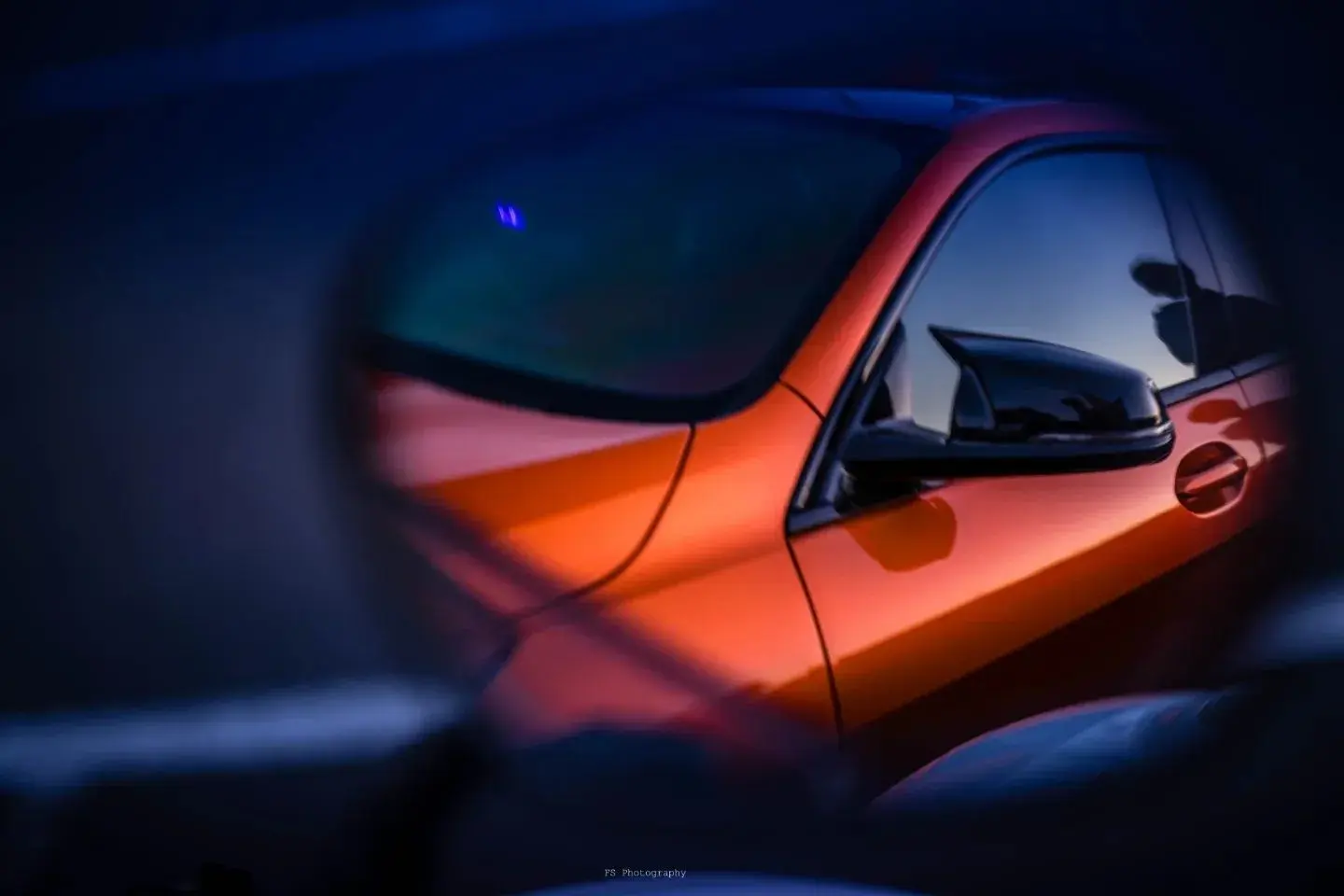 Reflet coloré sur la carrosserie d’une BMW orange