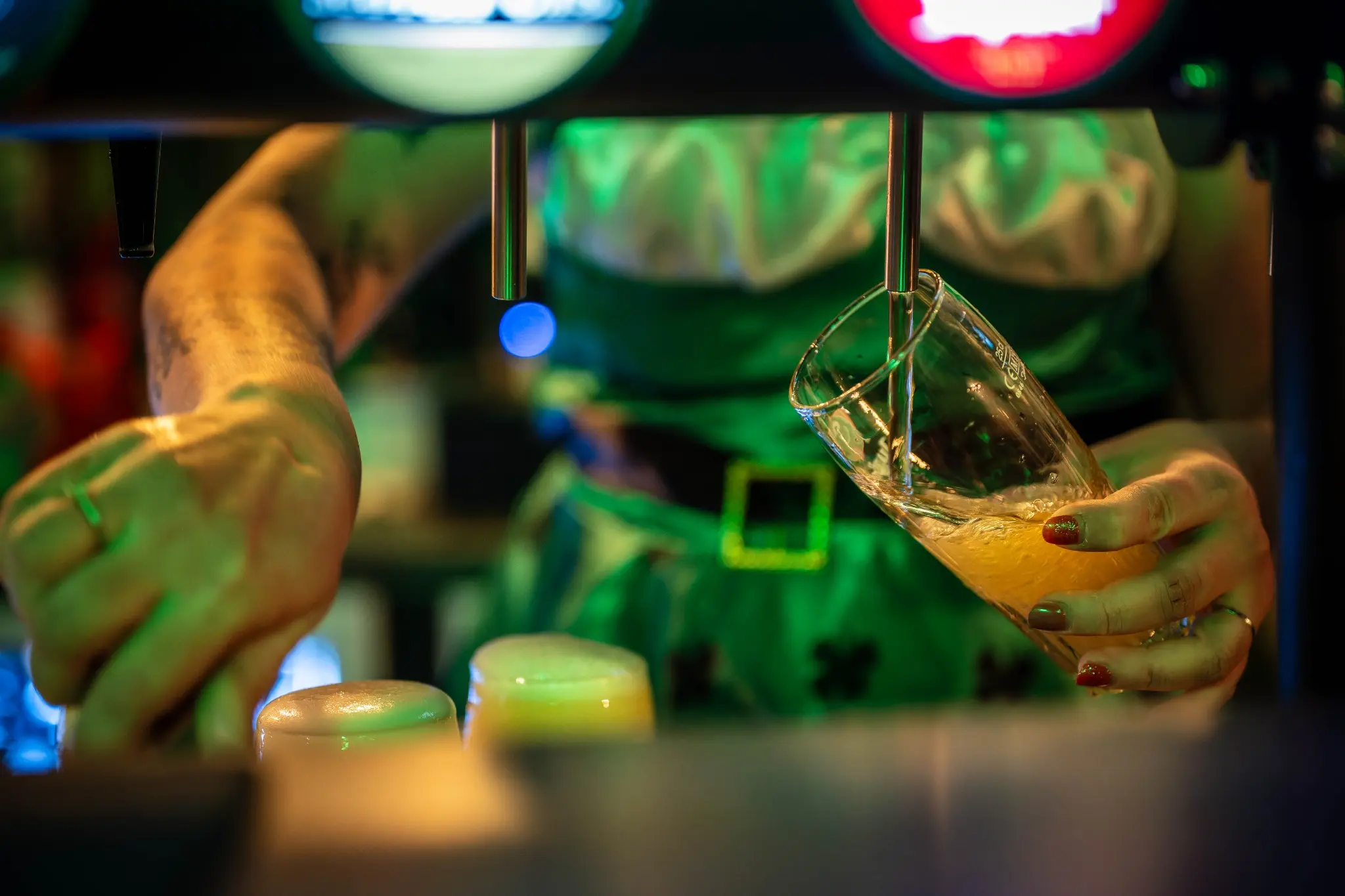 Bière servie sous les lumières vertes de la Saint-Patrick au bar Chez Marie