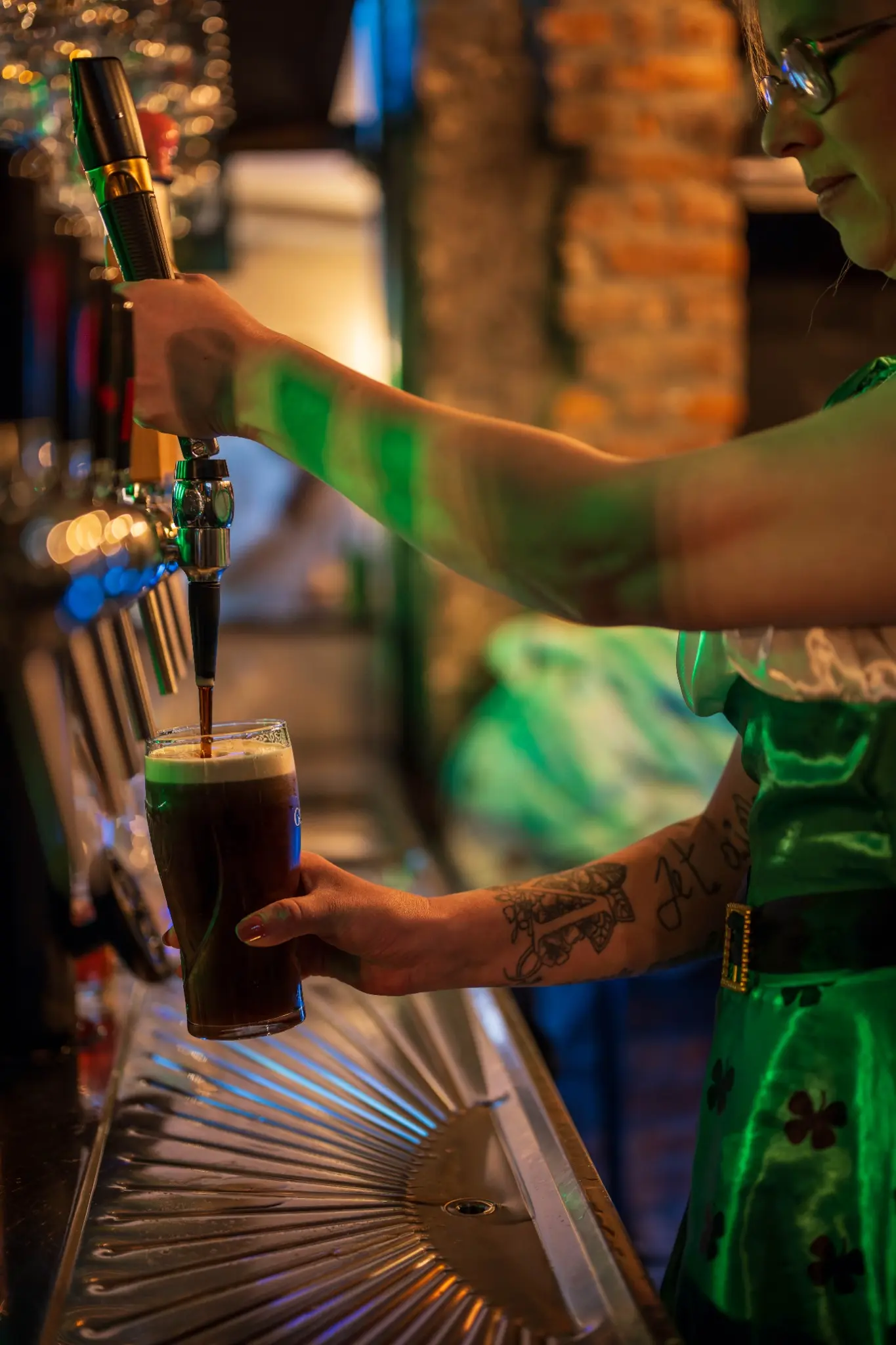 Serveuse tirant une Guinness pendant la Saint-Patrick au bar Chez Marie