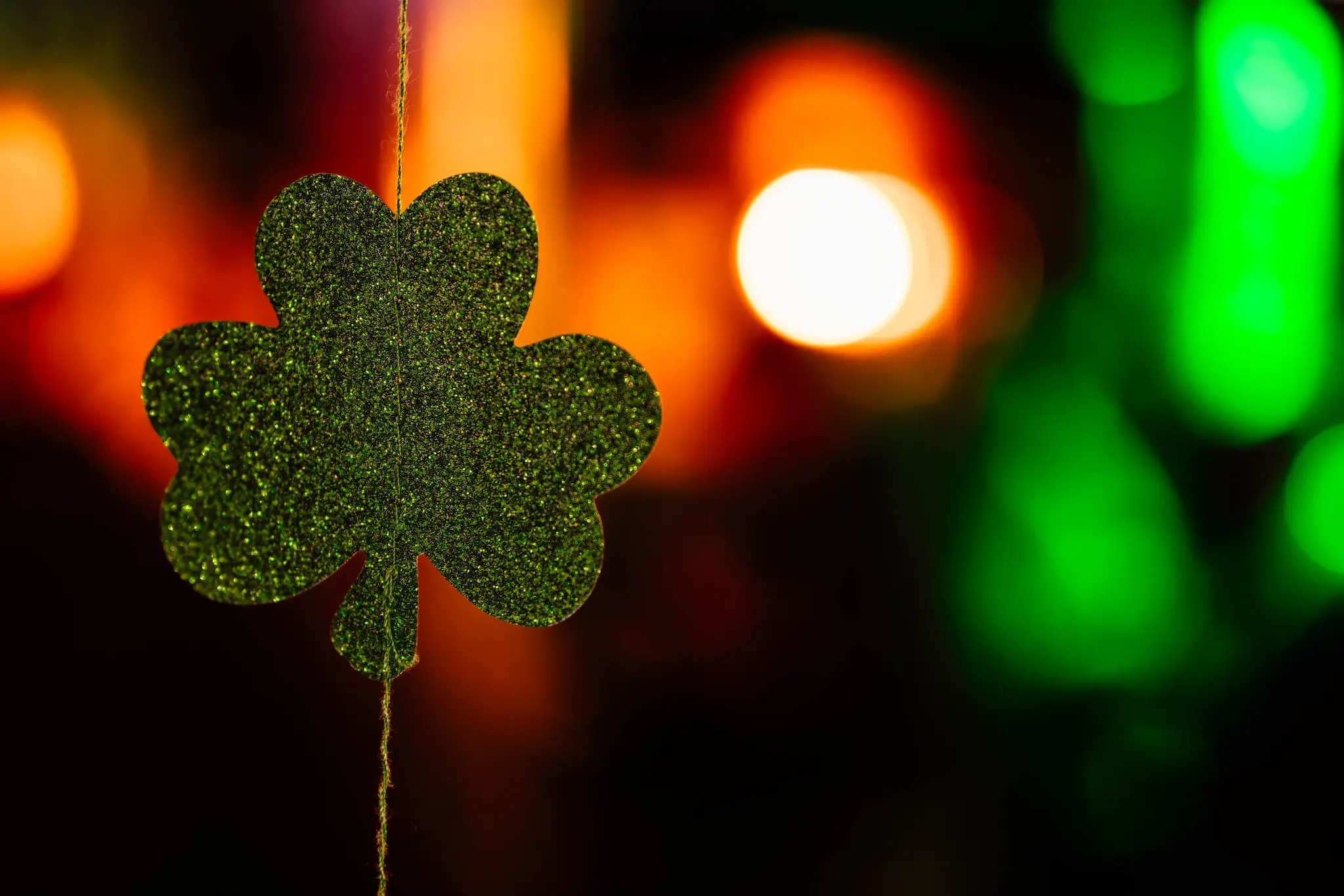 Trèfle vert suspendu devant les lumières de la Saint-Patrick au bar Chez Marie
