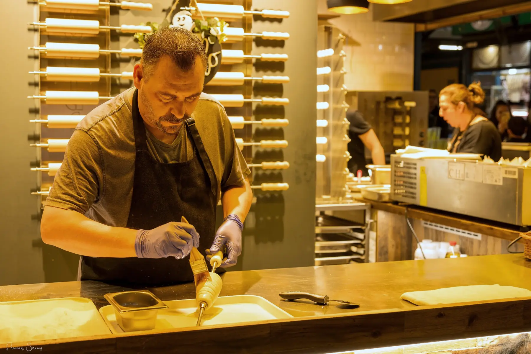 Artisan préparant une spécialité derrière son comptoir