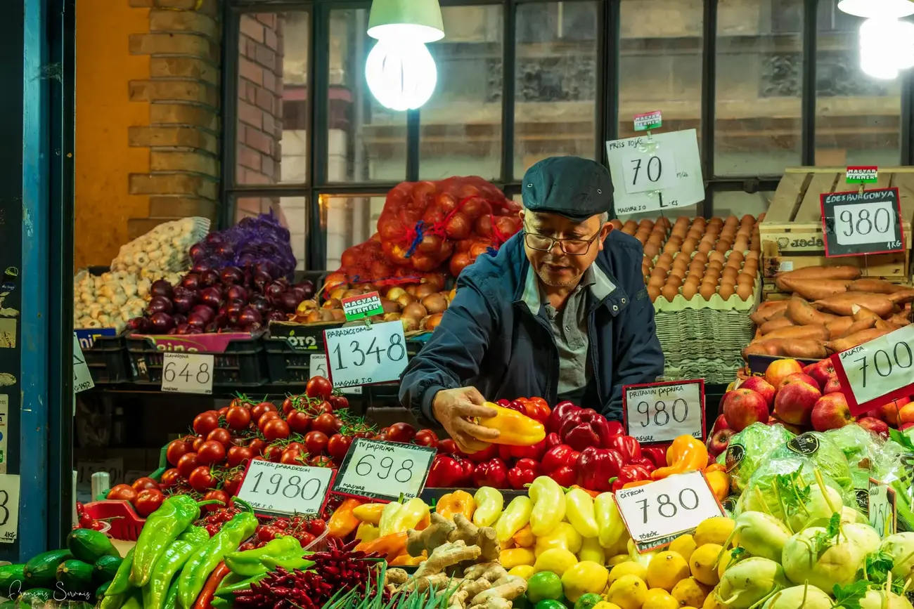 Commerçant présentant ses fruits et légumes sur un étal coloré
