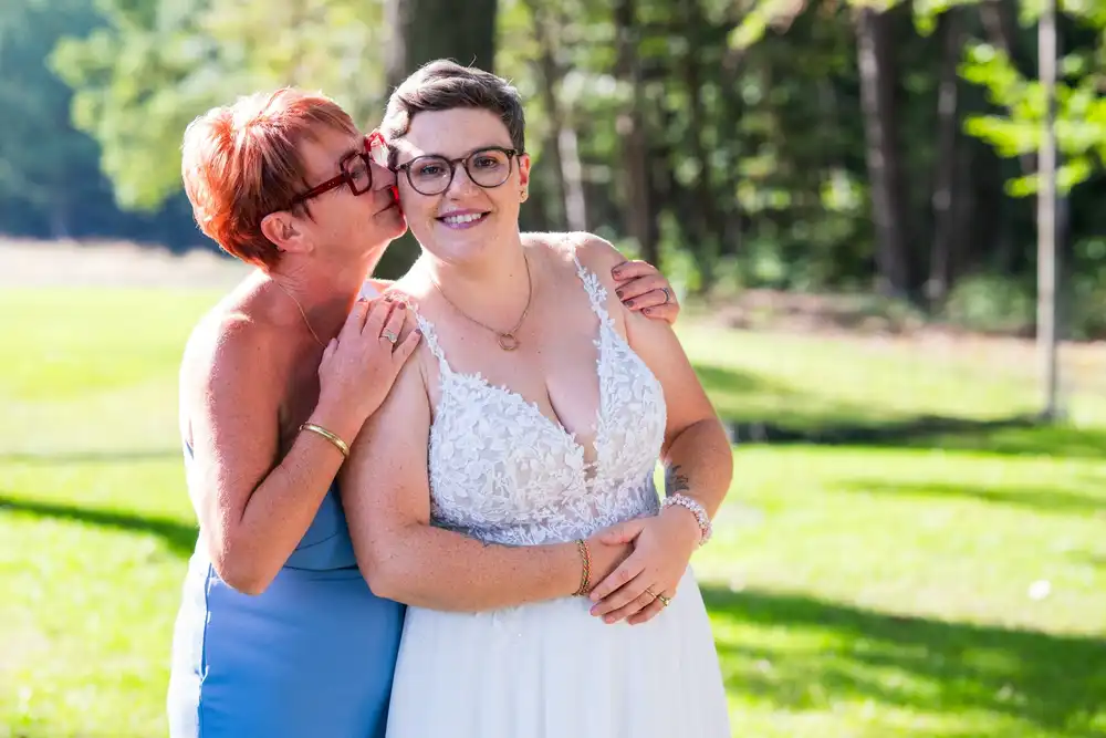 Une proche embrasse tendrement l’une des mariées pendant la réception