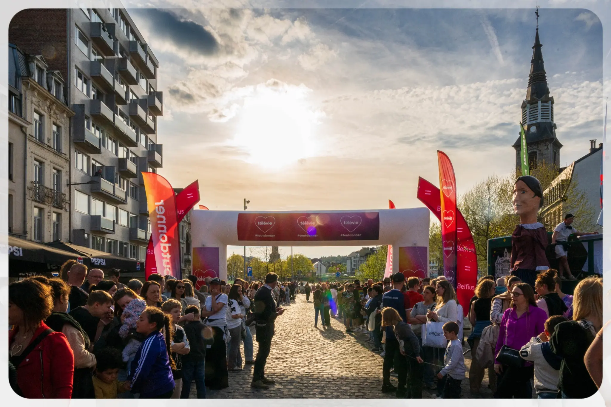 Foule réunie au coucher du soleil pour un événement culturel en ville