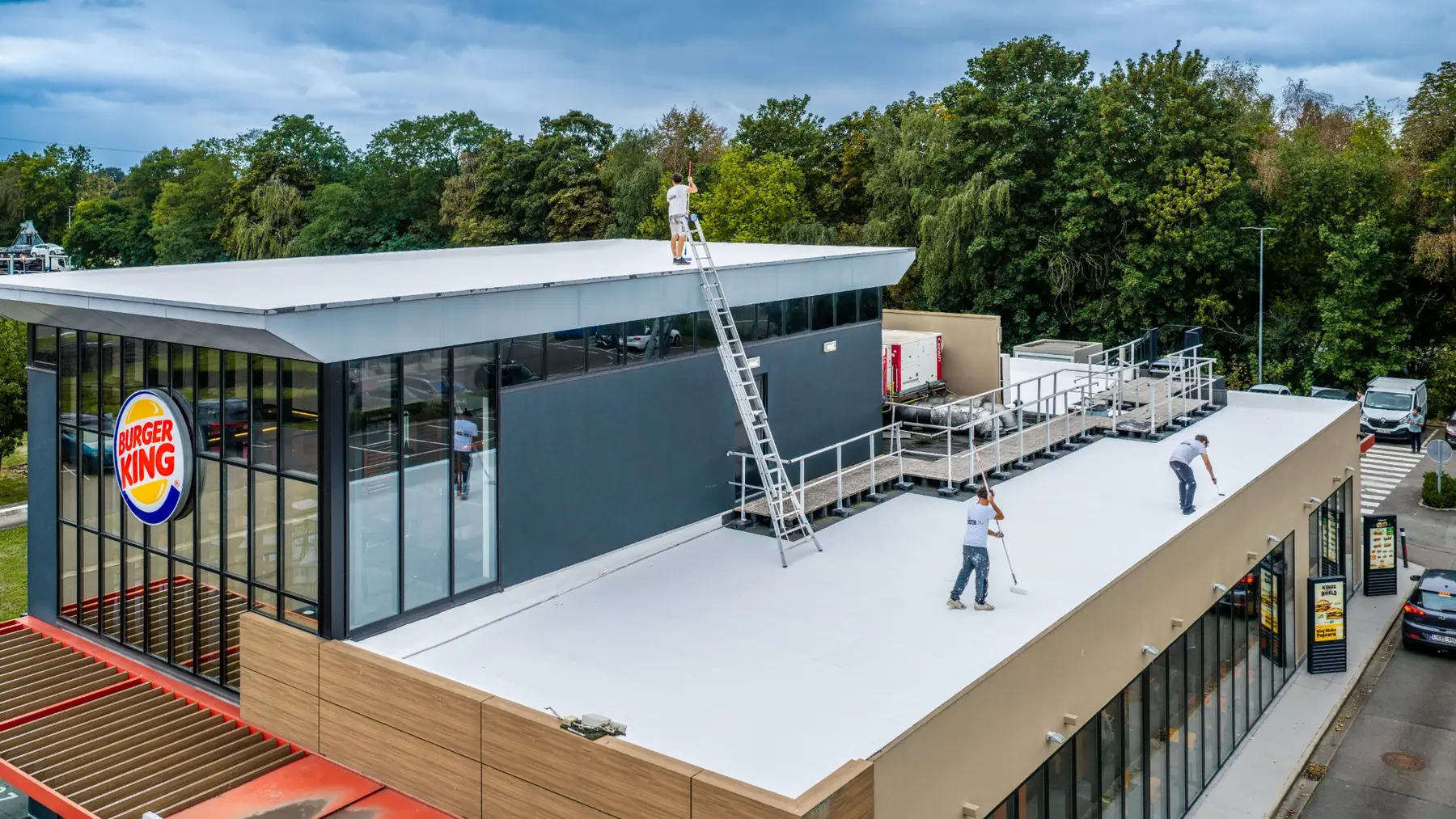 Équipe de Cool Roofing au travail sur la toiture du Burger King de Hognoul, photographiée par drone