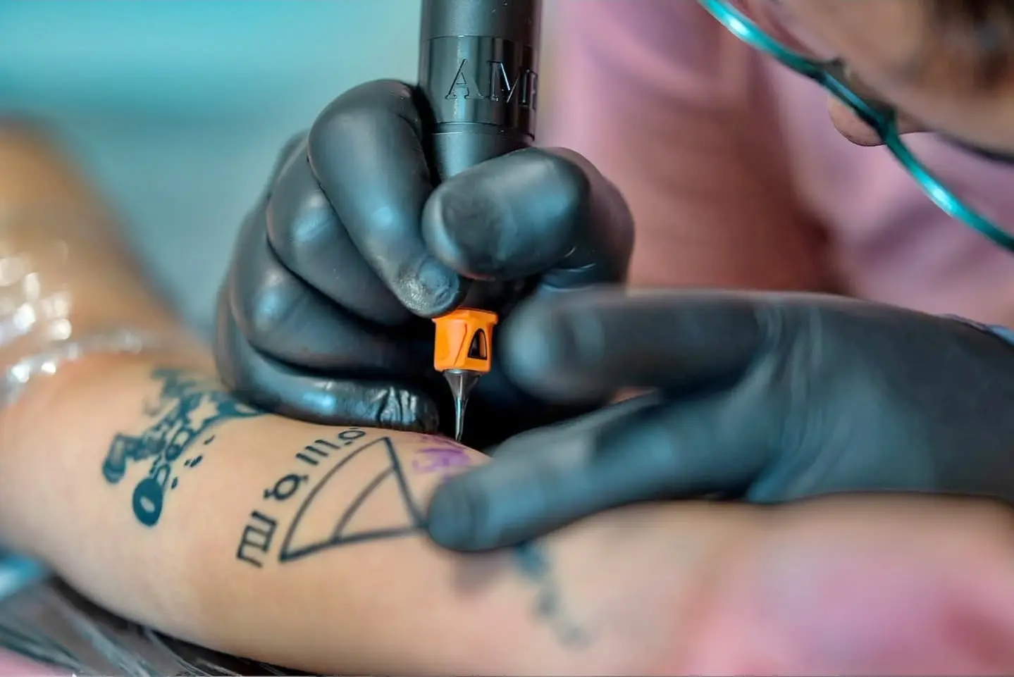 Geste précis pendant la réalisation d’un tatouage au studio Krow Ink Tattoo