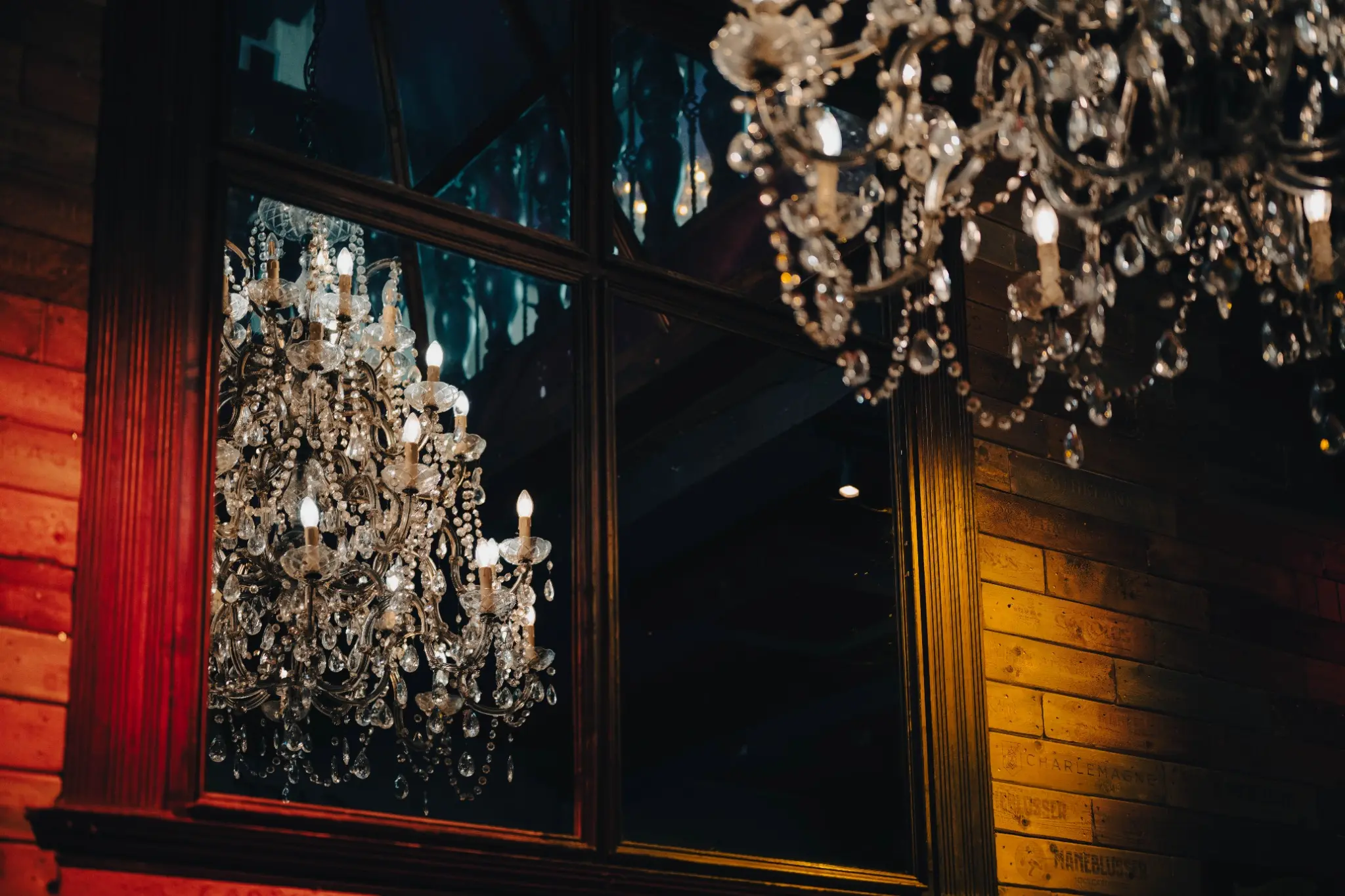 Chandelier, miroir et matières chaleureuses dans un établissement HoReCa