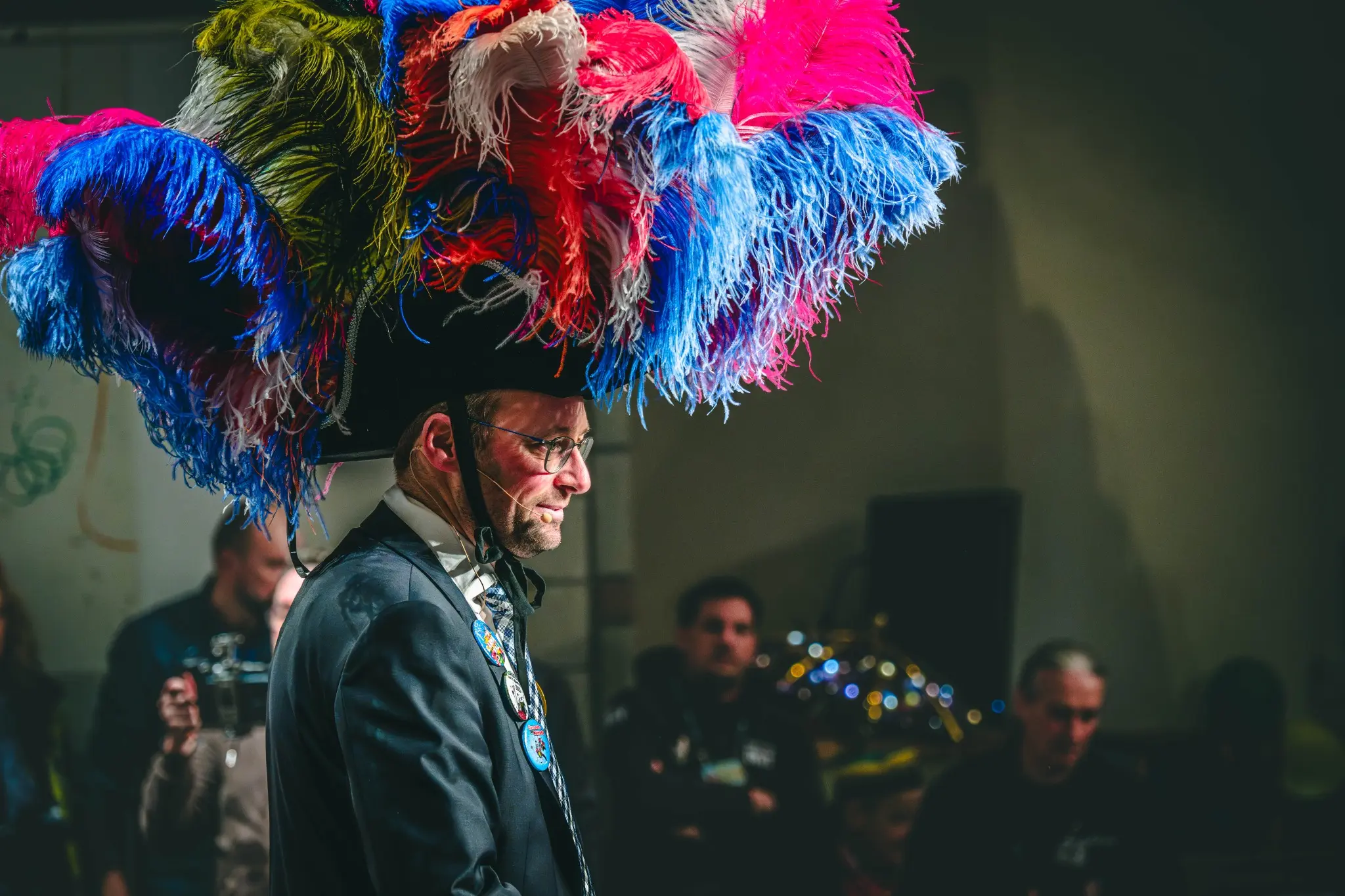 Jeune participant en chapeau et tenue de carnaval observant le spectacle, photographié en noir et blanc