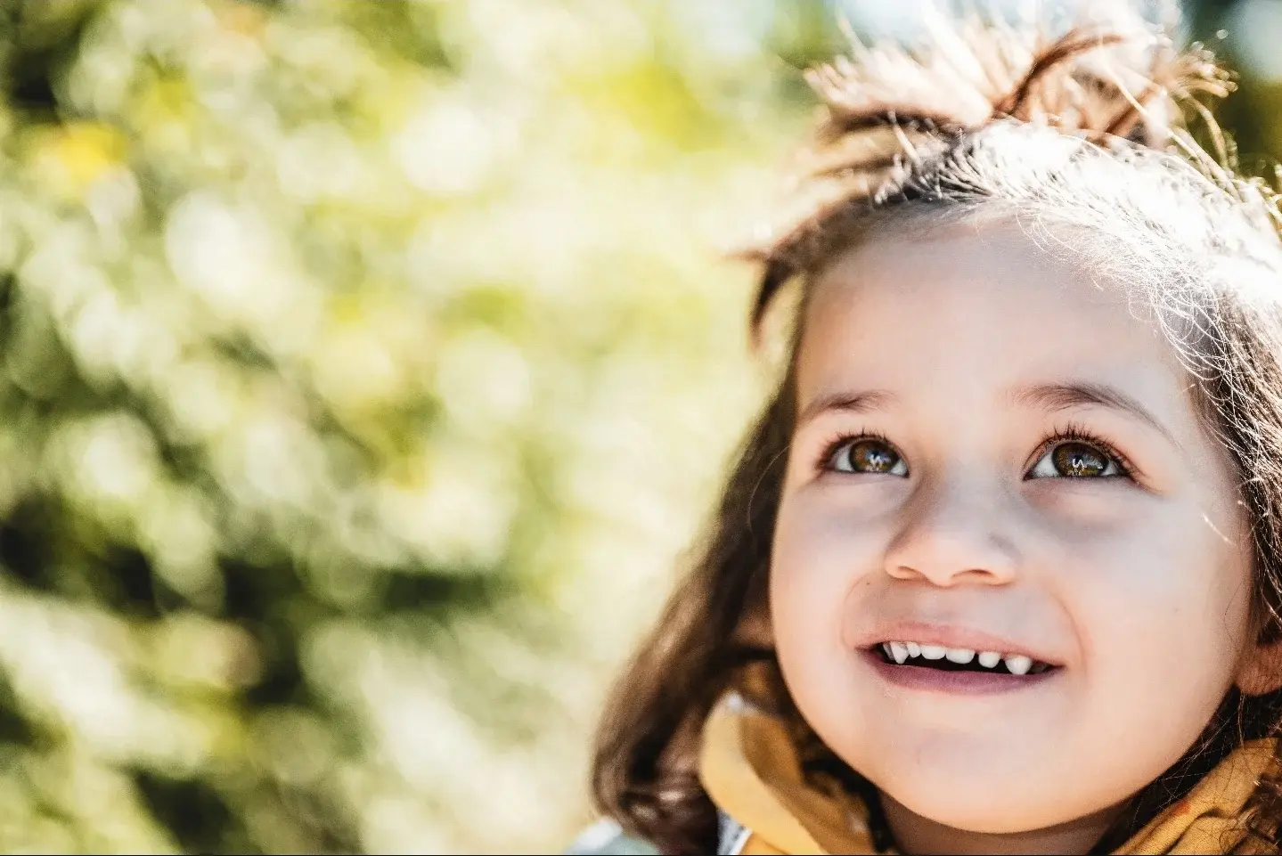 Portrait rapproché d’une enfant souriante dans une lumière dorée
