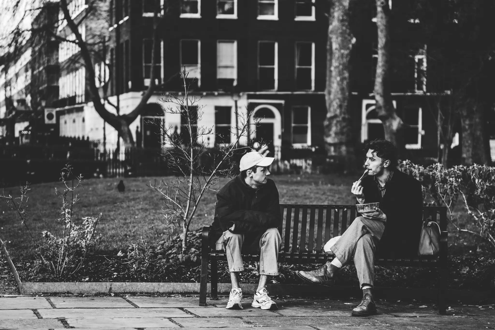 Deux hommes assis sur un banc au cours d’un instant de vie en noir et blanc