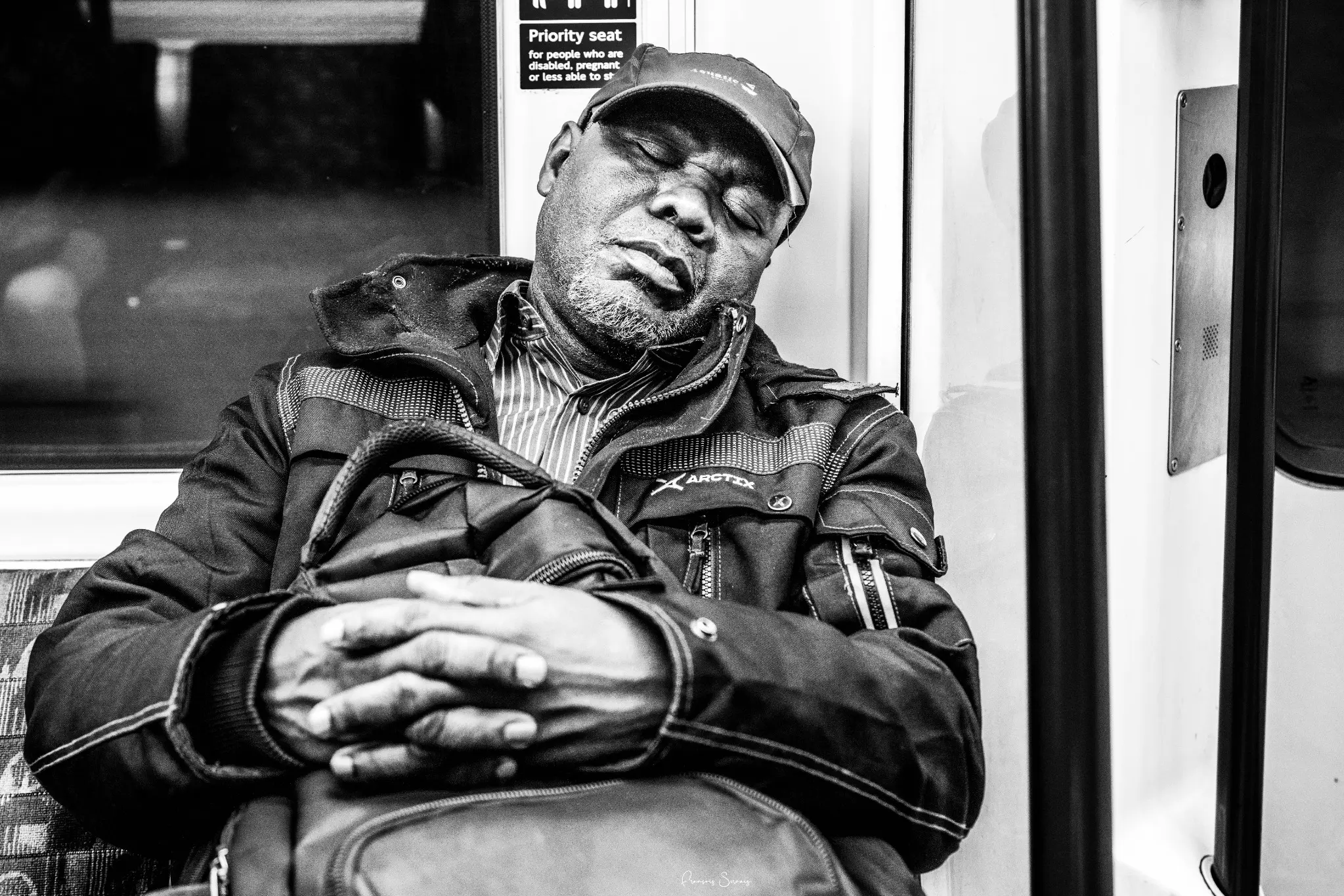 Passager endormi dans une rame, photographié en noir et blanc