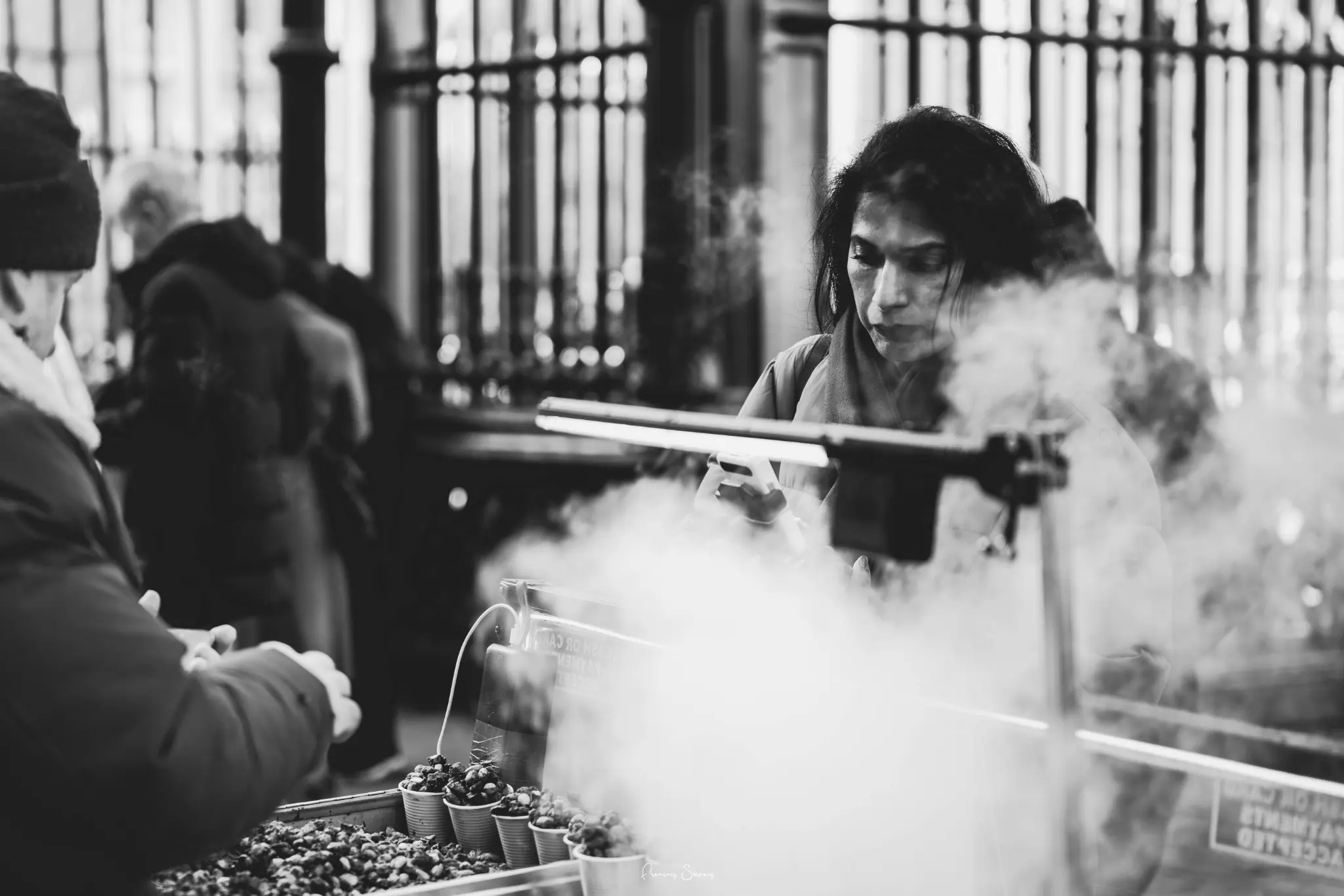Femme au travail derrière la vapeur d’un étal de cuisine de rue