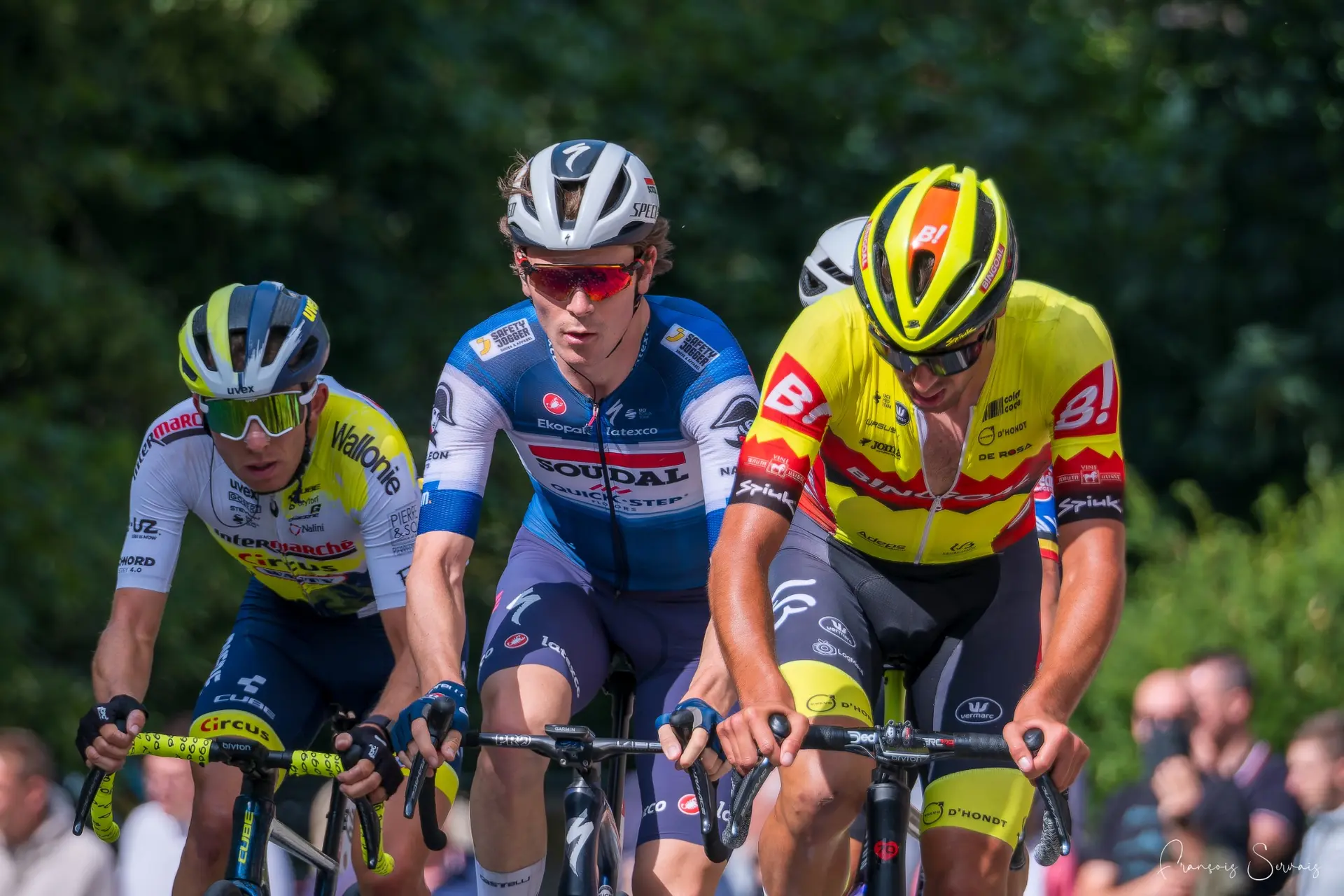Trois coureurs professionnels avancent côte à côte