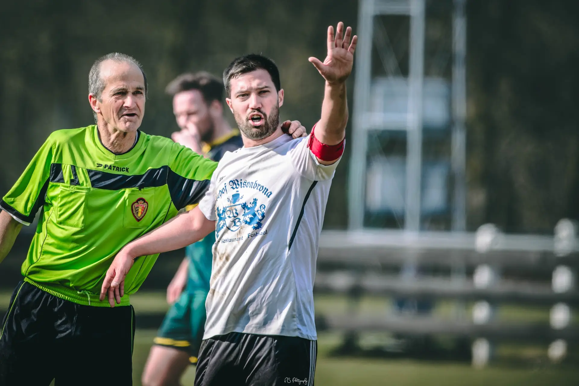 Capitaine de football échange avec l’arbitre sur le terrain