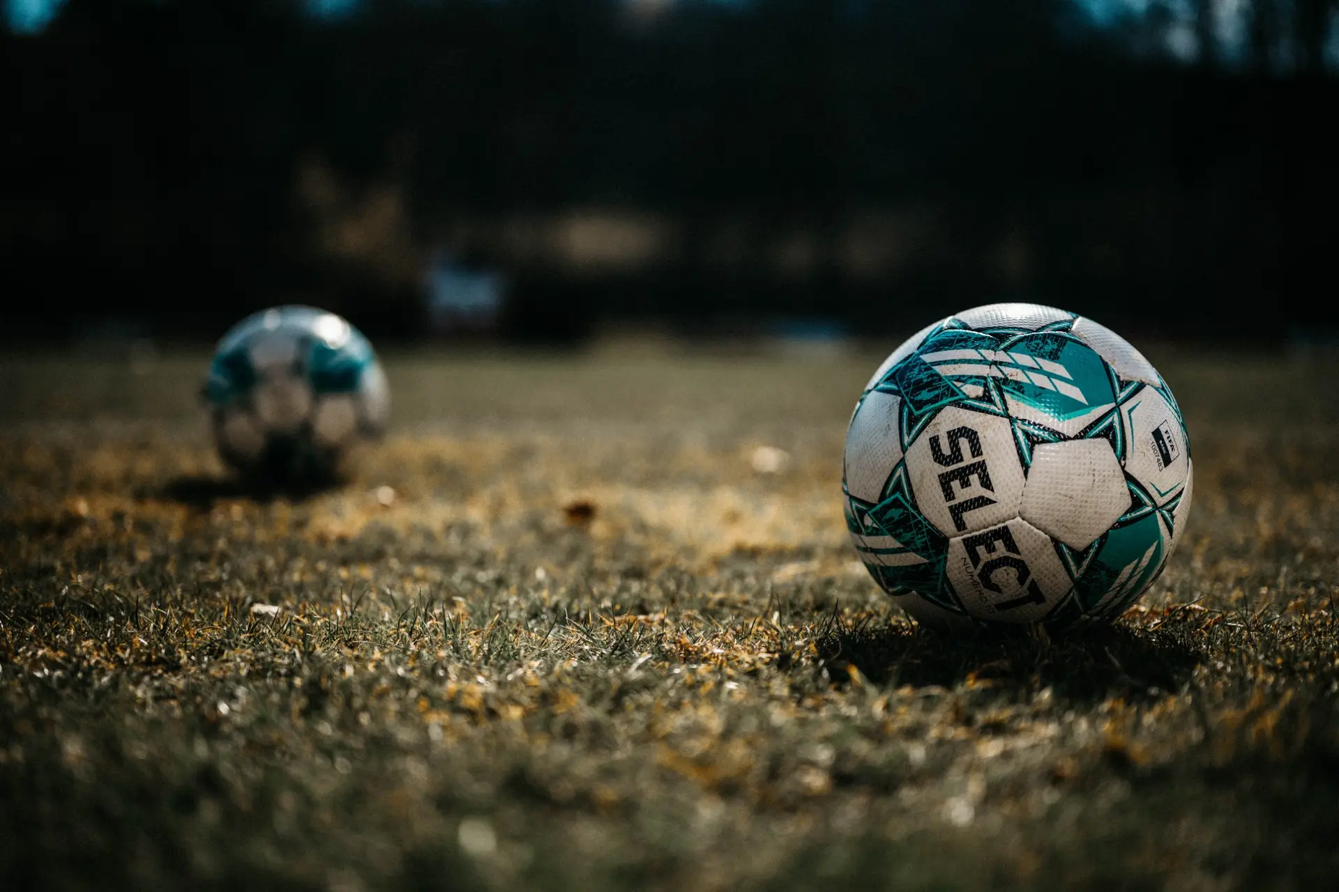 Ballons de football posés sur l’herbe avant la rencontre