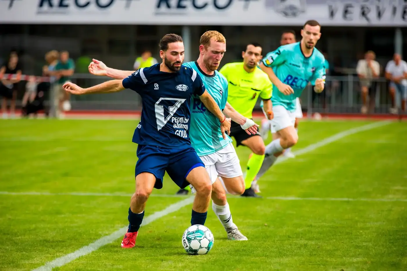 Joueur de football protège le ballon face à un défenseur