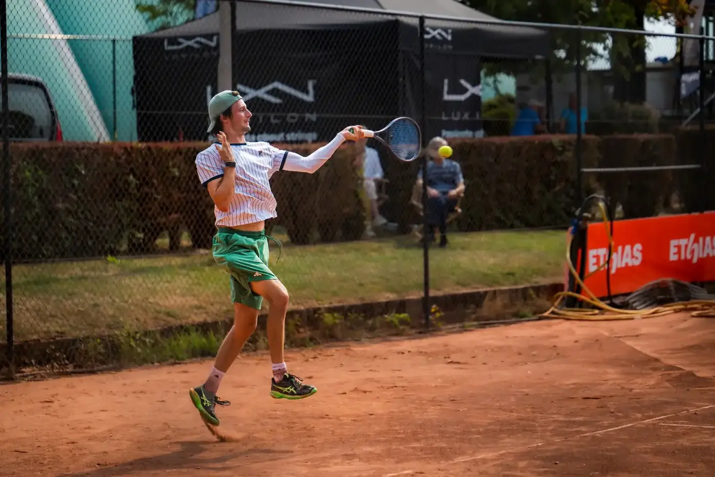 Joueur de tennis frappe un coup droit en mouvement sur terre battue