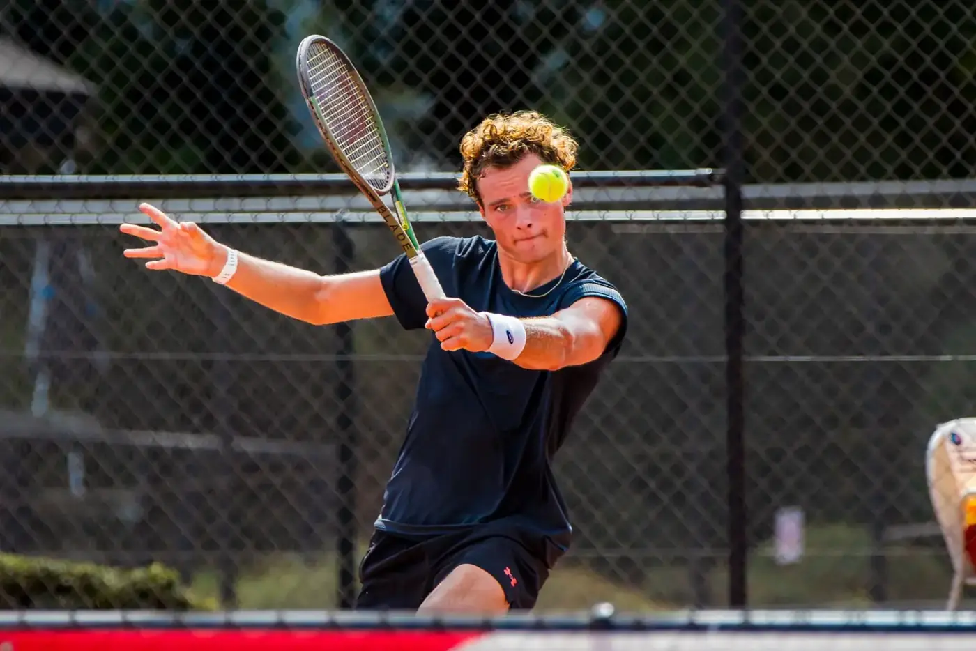 Joueur de tennis frappe un revers avec la balle devant le visage
