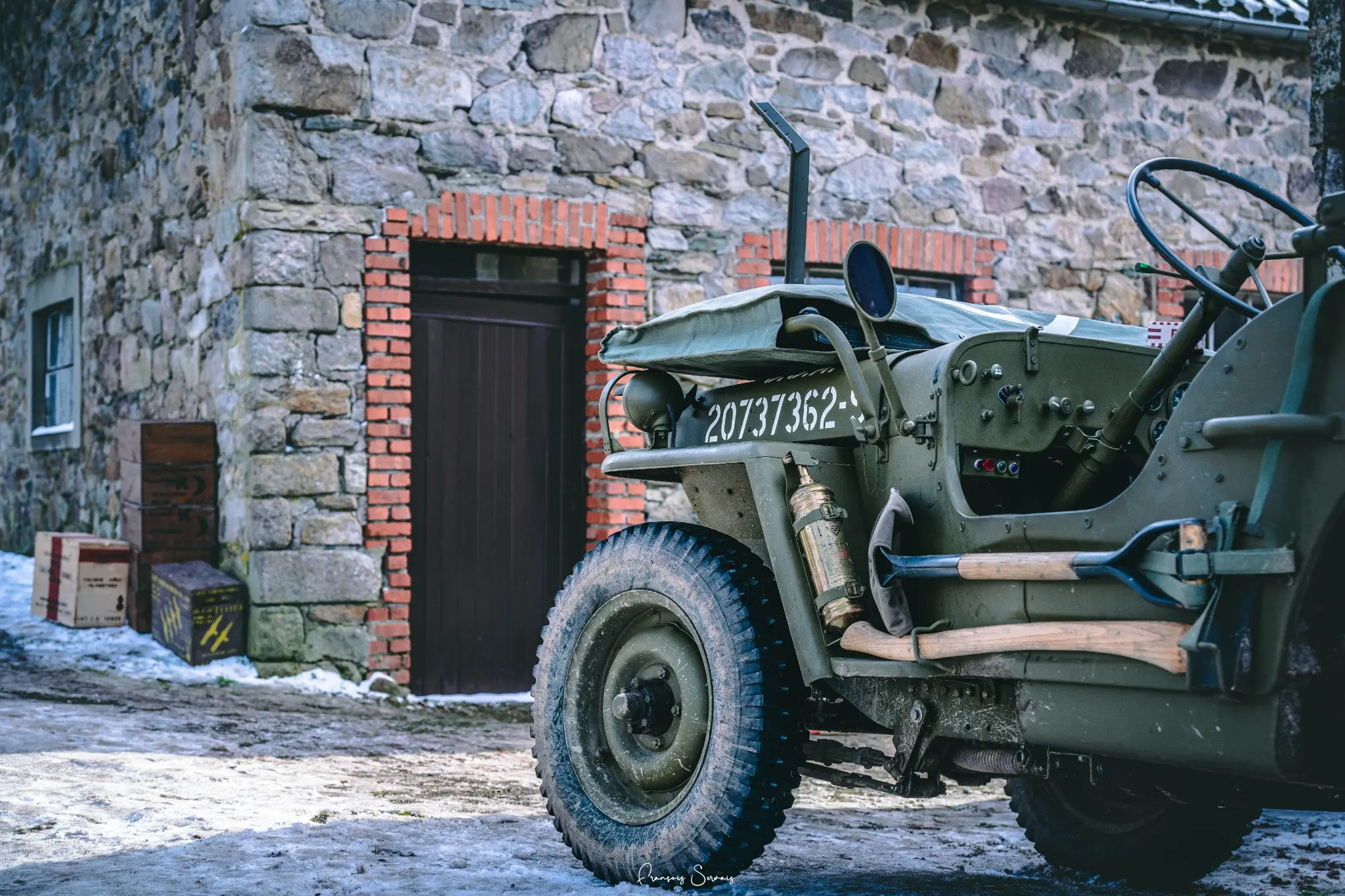 Jeep militaire d’époque devant une bâtisse en pierre pendant la reconstitution historique à Thirimont